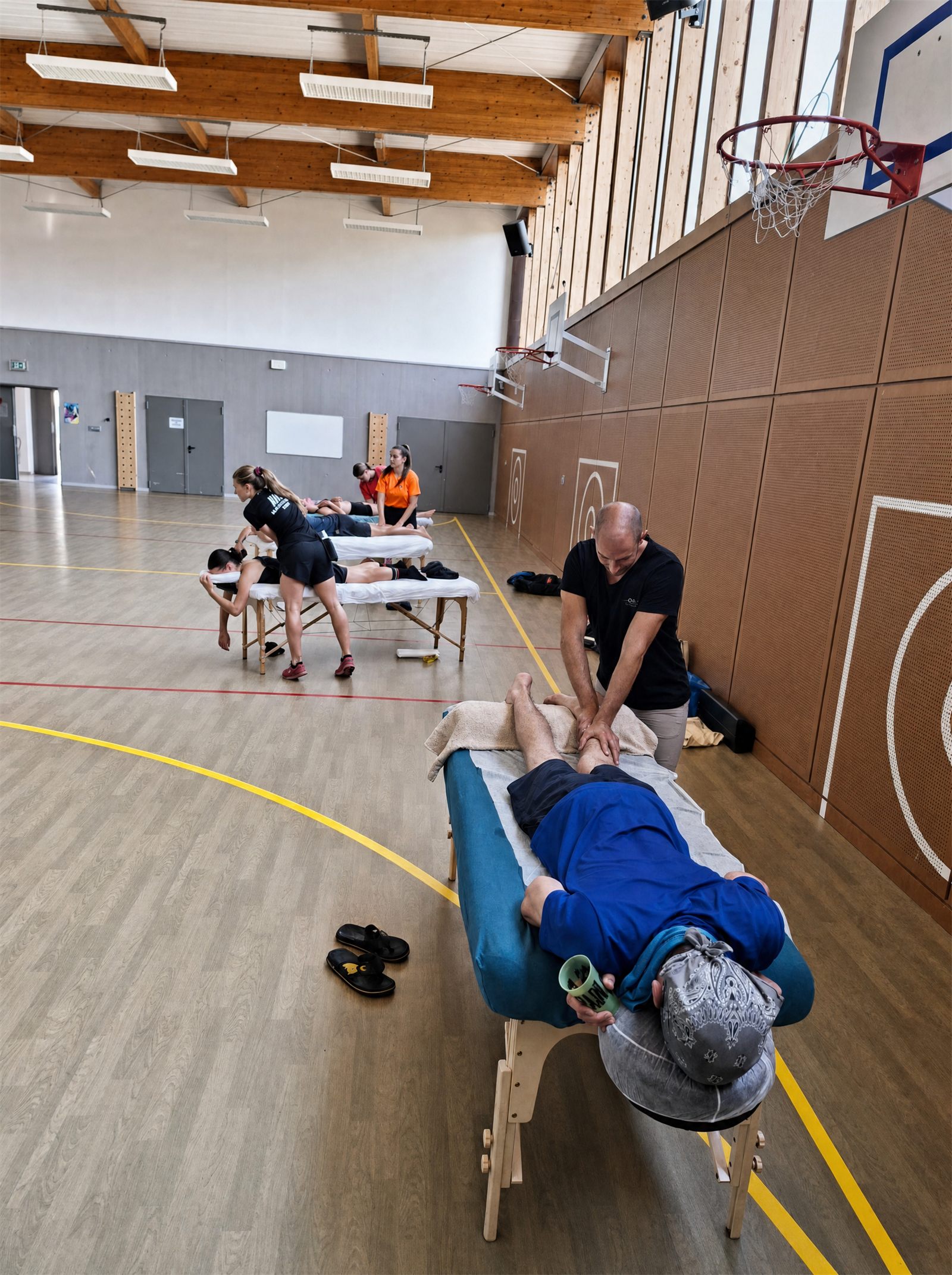 Plusieurs tables de massage en gymnase sur un cross